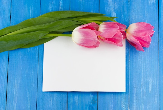 Roze tulpen op een blauwe houten tafel