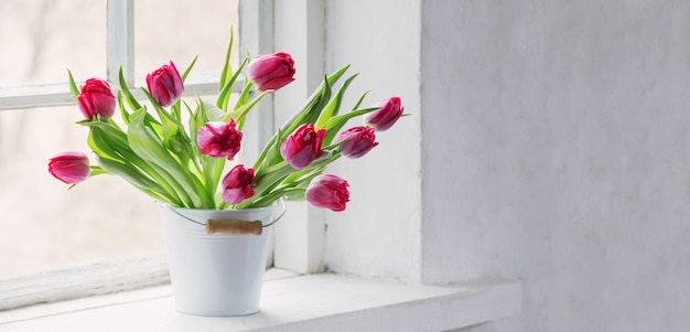 Roze tulpen op oude witte vensterbank