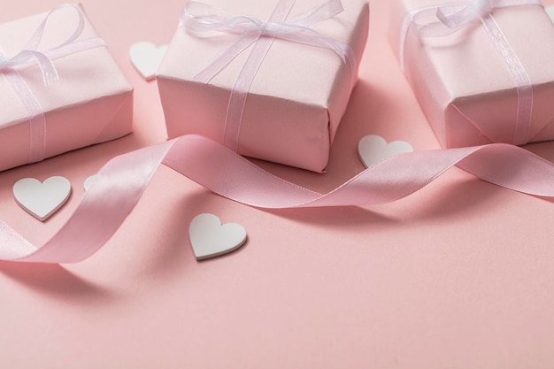 Roze valentijnscadeau met witte hartjes op een pastelroze achtergrond