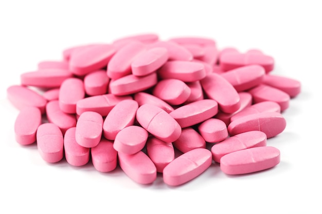 Roze vitaminepillen voor vrouwen op een witte achtergrond. Multivitaminen voor de gezondheid van vrouwen, isoleren, vrije ruimte