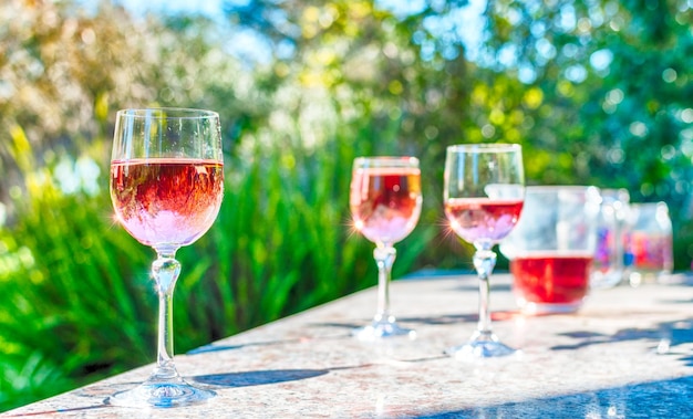 Roze wijn in glazen met steel op een tafel in een tuin