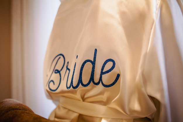 roze zijden gewaad van de bruid met het opschrift van de bruid op haar rug.