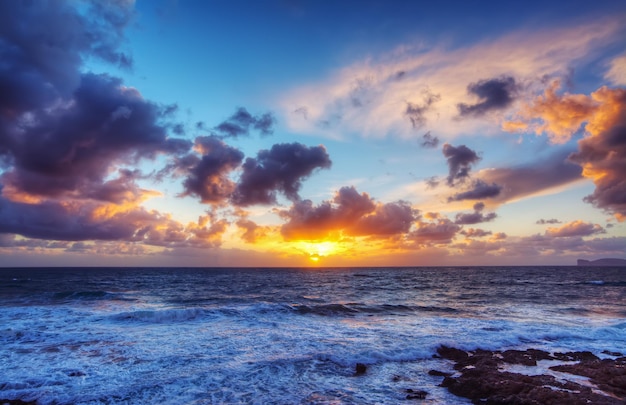 Roze zonsondergang over de kustlijn van Alghero, Italië