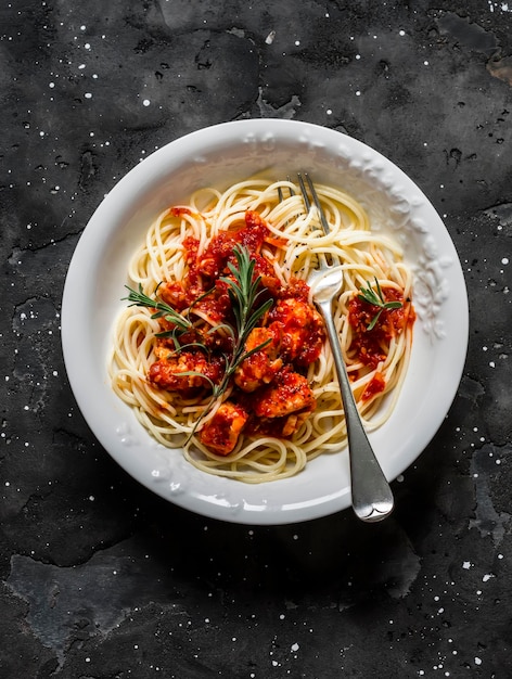 Rozemarijn kip tomatensaus chili peper spaghetti op een donkere achtergrond bovenaanzicht Heerlijke lunch
