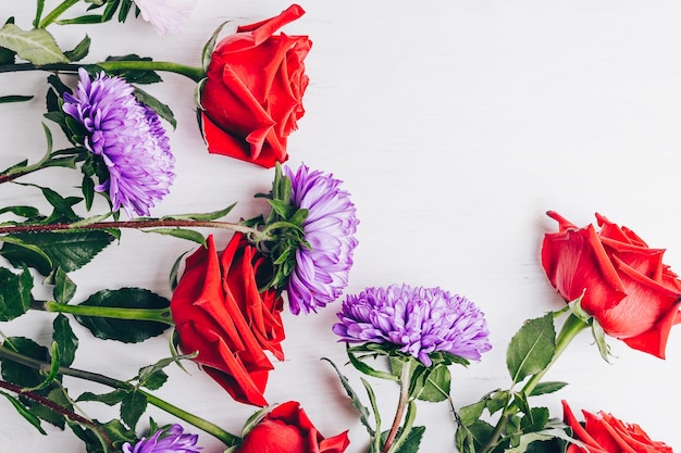 Foto rozen en chrysanten op een lichte tafel kopieer ruimte close-up