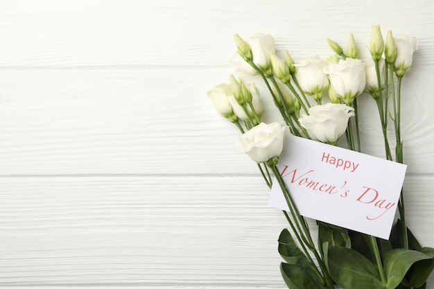 Rozen en tekst Happy Women's Day op witte houten achtergrond