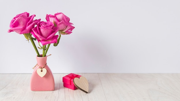 Foto rozen in vaas met geschenkdoos op tafel