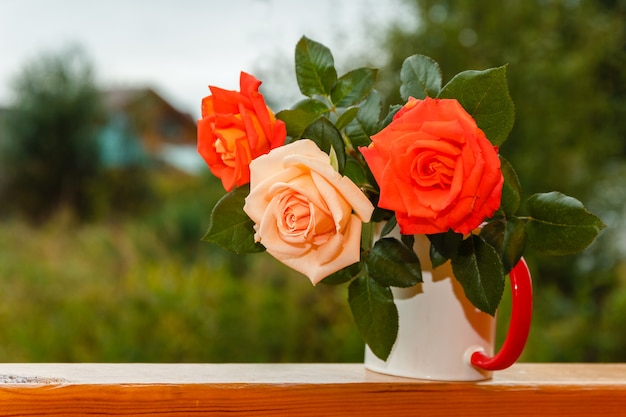 rozen staan ​​op houten veranda op de achtergrond van een landhuis