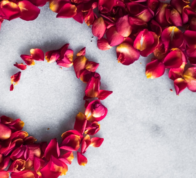 Rozenblaadjes op marmeren achtergrond bloemen decor en bruiloft flatlay vakantie wenskaart achtergrond voor...