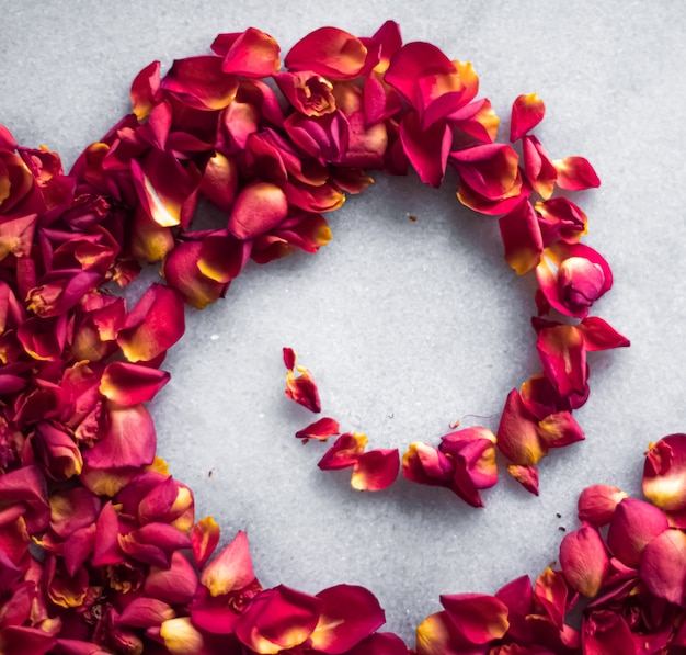 Rozenblaadjes op marmeren achtergrond bloemendecor en bruiloft flatlay vakantie wenskaart achtergrond voor...