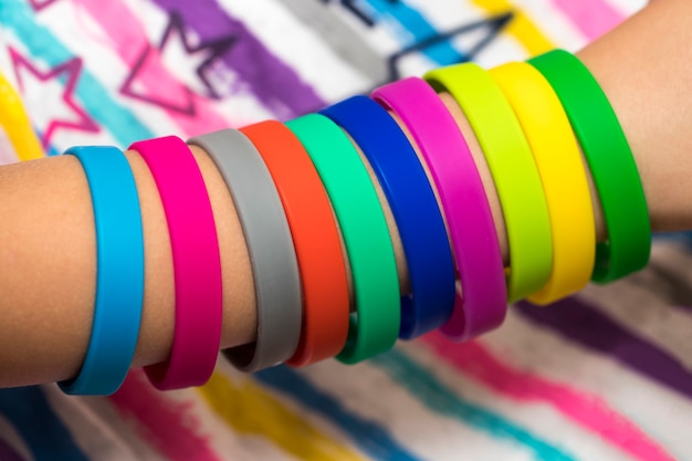 Elastici a portata di mano. mano delle ragazze con bracciali fatti di elastici. elastici colorati telaio arcobaleno.