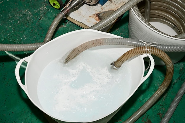 Rubber basket with disinfectant liquid for cleaning a cheese factory