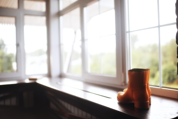 rubber boots / autumn shoes in apartment, background with autumn boots, seasonal shoes, boots for rain, November background concept of autumn