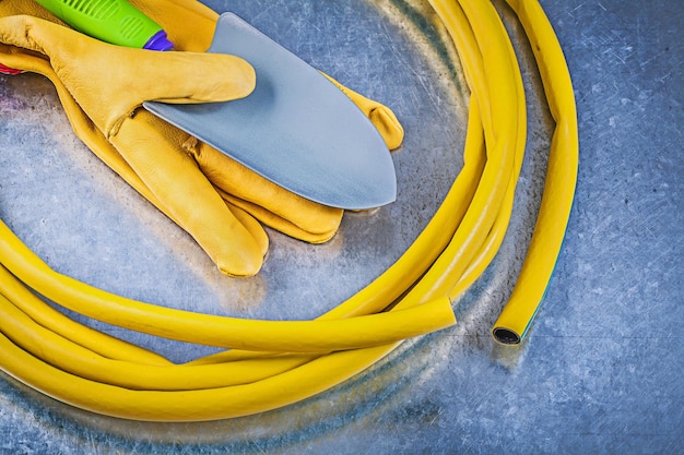 Rubber tuinslang beschermende handschoenen hand spade op metalen achtergrond tuinieren concept