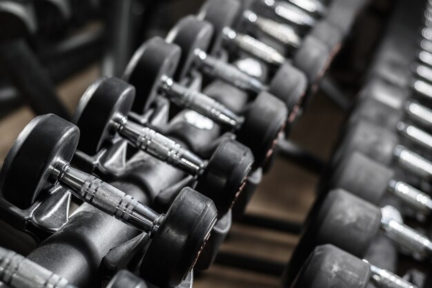 Rubbered Dumbbells on a stand in the gym