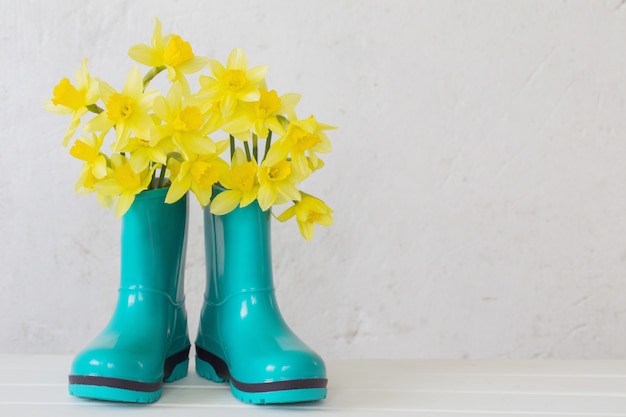 Rubberlaarzen en de lentebloemen op witte achtergrond