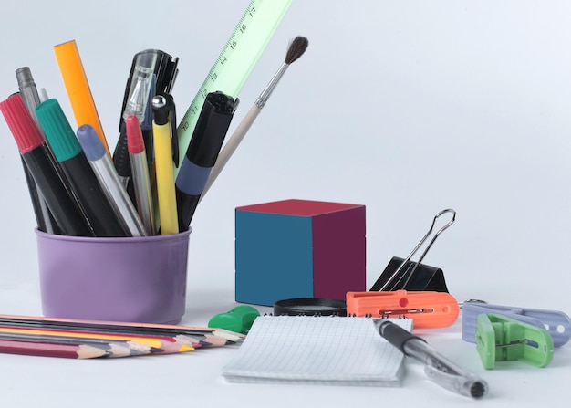 Foto cubo di rubik e materiale scolastico isolato su sfondo bianco