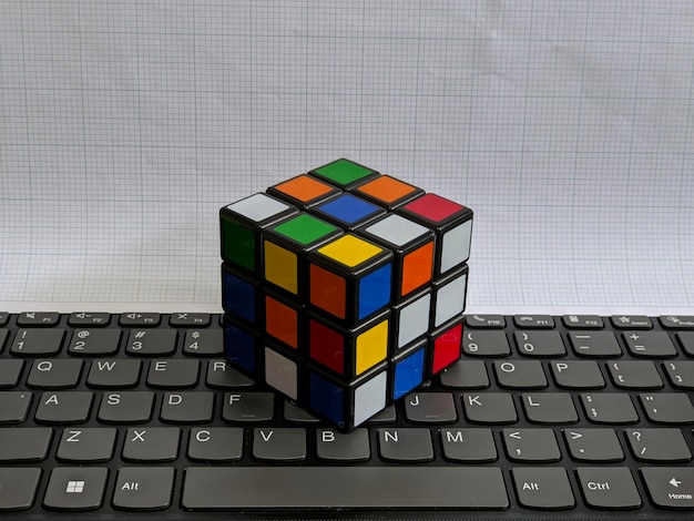 Photo a rubik's cube sits on a keyboard