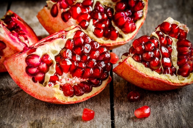 Ruby granaatappel korrels close-up in een houten kom op een rustieke tafel