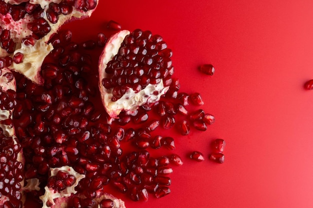 Ruby rijpe verse, sappige gesneden granaatappel geïsoleerd op rode achtergrond