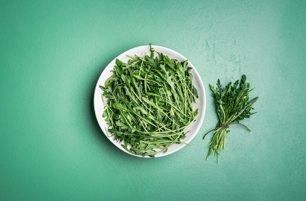 Rucola salade en rucola bundel op groene tafel