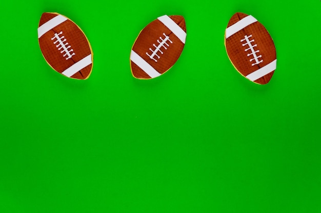 Rugby balls cookie on green background. American football background.