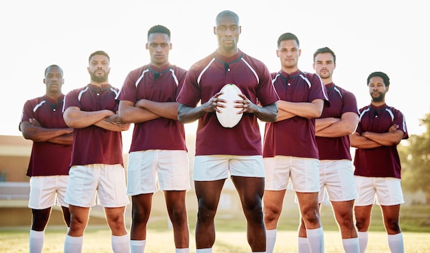 Foto rugby uomo di colore con palla e ritratto di squadra sul campo solidarietà e fiducia per la vittoria del gioco diversità leadership e gruppo di lavoro di squadra di persone sportive forti che stanno insieme al potere sul campo