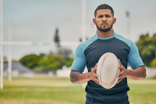 Rugby field and portrait of man with ball serious expression and confidence in winning game Fitness sports and player training for match workout or competition on grass at stadium with mockup