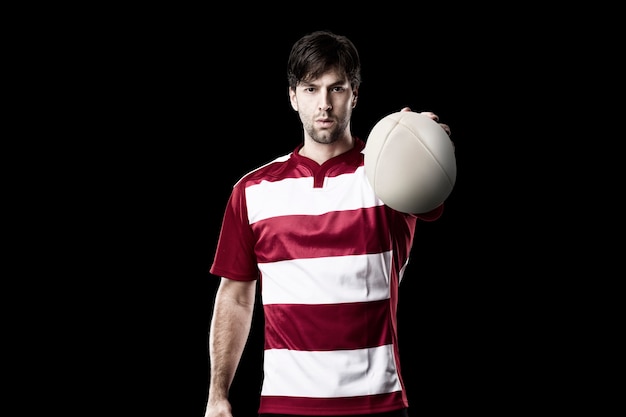 Rugby player in a red uniform. Black wall