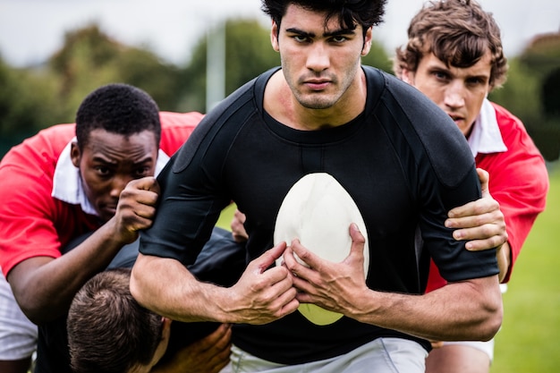 Photo rugby players tackling during game