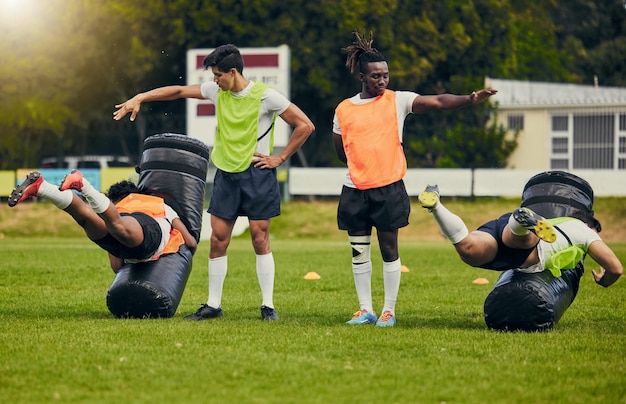 Rugby tackle and men training on field with equipment ready for match practice and sport games Fitness teamwork and male athletes for warm up performance exercise and workout for competition