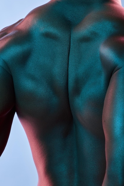 Foto rugspieren en lichaam van zwarte man in studio voor fitnessresultaten en gezonde levensstijl op blauwe achtergrond schouders buigen en mannelijk model poseren voor het trainen van sterke en gespierde esthetiek