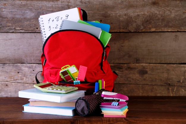 Rugzak met schoolspullen op oude houten tafel