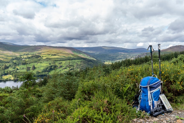 Rugzak, verrekijker, kaart en stokken op de berg, berg levensstijl in Ierland.