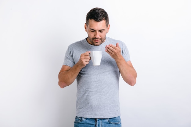 Ruikt geweldig. taille-up portretweergave van de knappe man die staat en de geur van de koffie uit de beker ruikt. ochtend dranken concept. stock foto