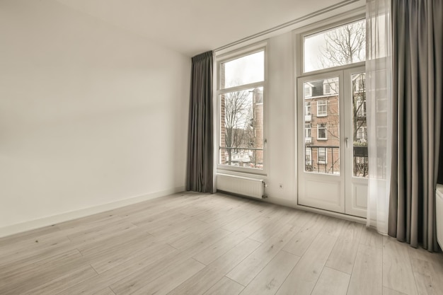 Ruime kamer in minimalistische stijl met grote ramen en toegang tot het balkon