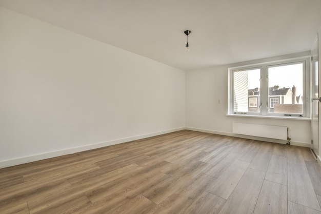 Foto ruime lege kamer in wit met parketvloer en raam in een modern huis