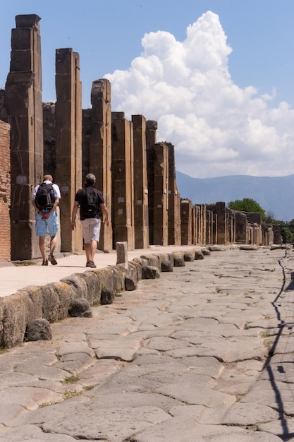 Ruined Pompeii landmark Tourists at Pompeii streets Archeology concept Ancient heritage