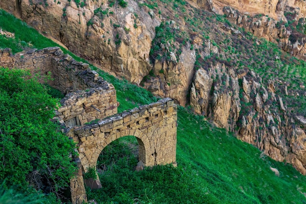 Ruïnes van stenen muren op een steile berghelling in een verlaten hooglandersdorp Gamsutl in Dagestan