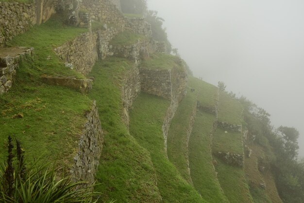 Ruins of the ancient Inca city machu picchu in fog Peru