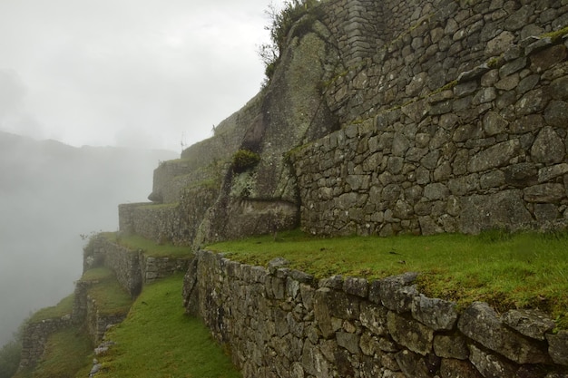 Ruins of the ancient Inca city machu picchu in fog Peru