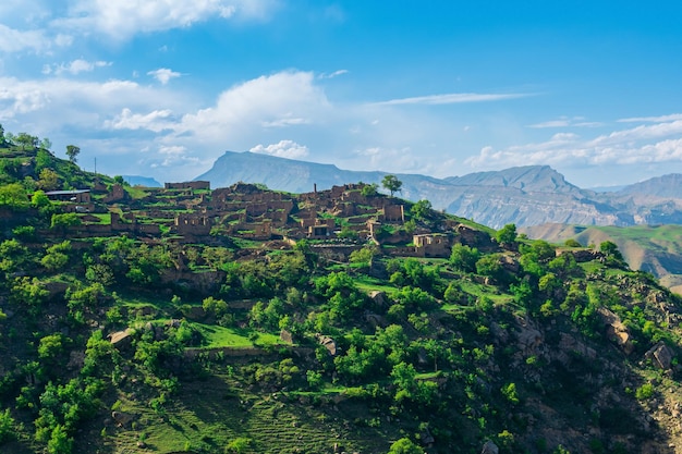 Ruins of houses on a mountainside in Kurib a depopulated village with the only remaining household with an apiary Dagestan another village Chokh is visible in the distance