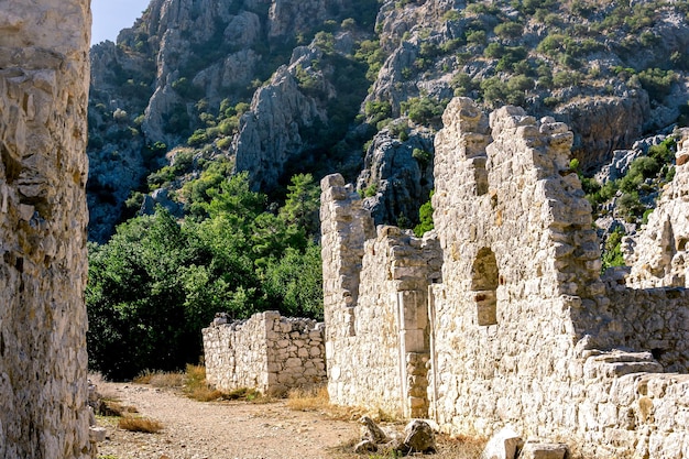 トルコ、オリンポスのアンティーク都市の山々を背景にした古代の建物の遺跡