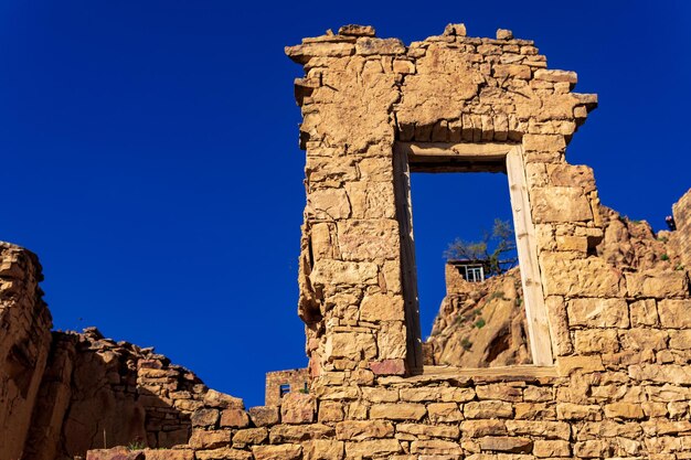 일몰 광선에 인구가 적은 Gamsutl 마을의 벽 유적