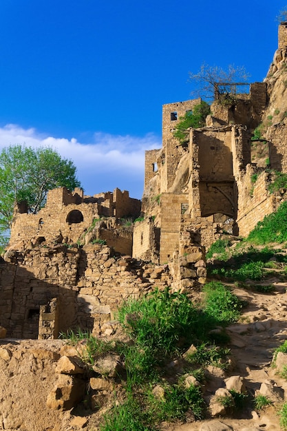 Ruins of walls of houses on a cliff in the abandoned village of Gamsutl