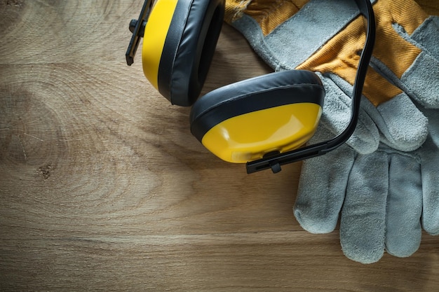 Ruisonderdrukking oorbeschermers veiligheidshandschoenen op houten plank