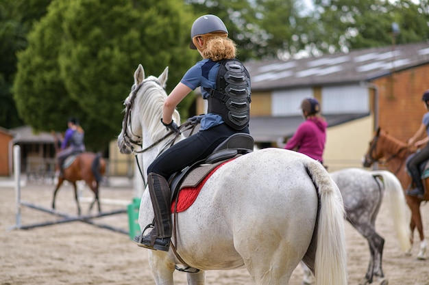 Ruiter in beschermend korset voor de wervelkolom op een wit paard