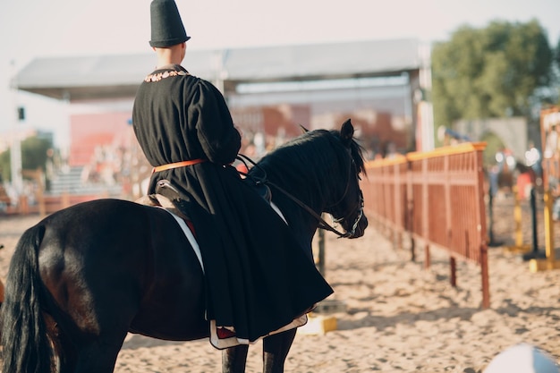 Ruiterman in middeleeuwse kleding op een zwart paard