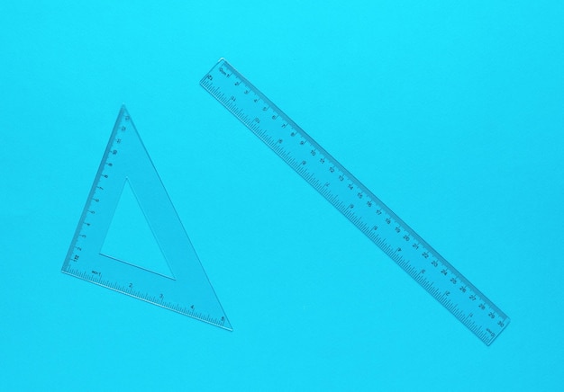 Photo ruler and triangle made of transparent plastic on a blue background