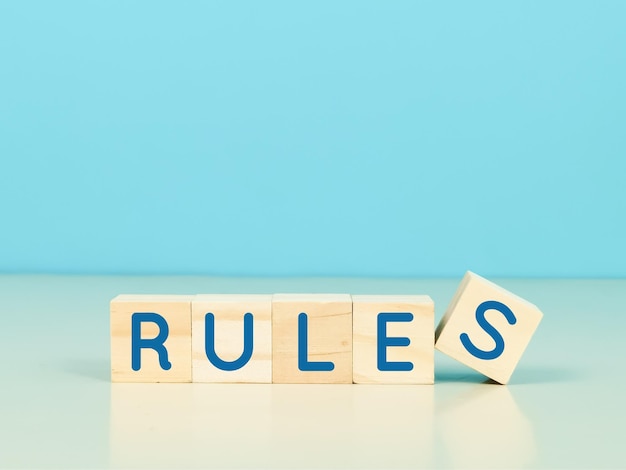 Rules and regulations concept. wooden cubes written rules on blue background